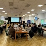 Prezentacja i dyskusja uczestników spotkania przy wspólnych stołach.